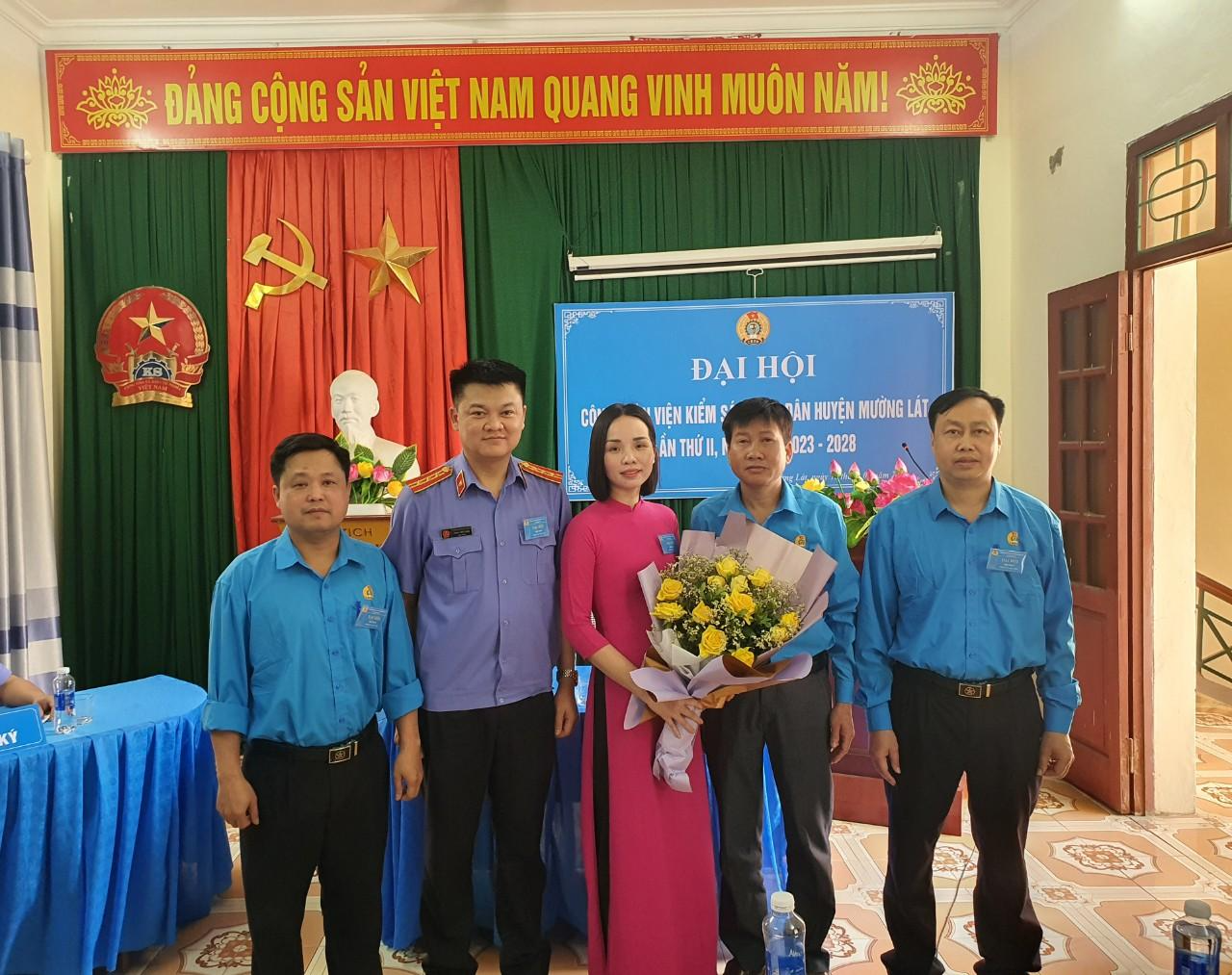 Đồng chí Lương Xuân Cường và đồng chí Phạm Tiến Dũng tặng hoa chúc mừng Ban chấp hành Công đoàn Viện kiểm sát huyện Mường Lát nhiệm kỳ 2023-2028