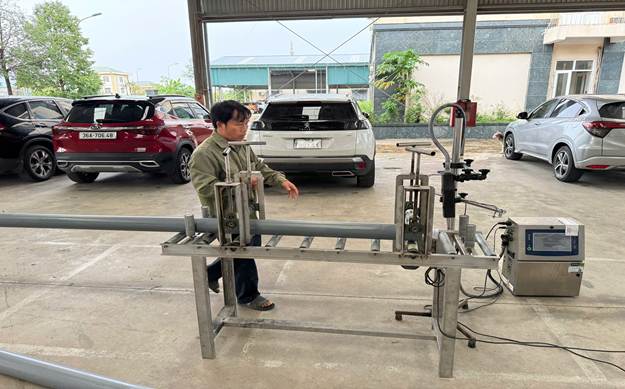Ảnh: Các bị can đang tẩy dòng chữ trên ống nhựa của hãng Tiến Phương để phun lên dòng chữ Tiền Phong