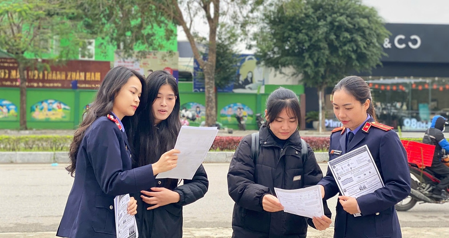 Hình ảnh: Kiểm sát viên của VKSND khu vực 1 phát tài liệu tuyên truyền cho người dân