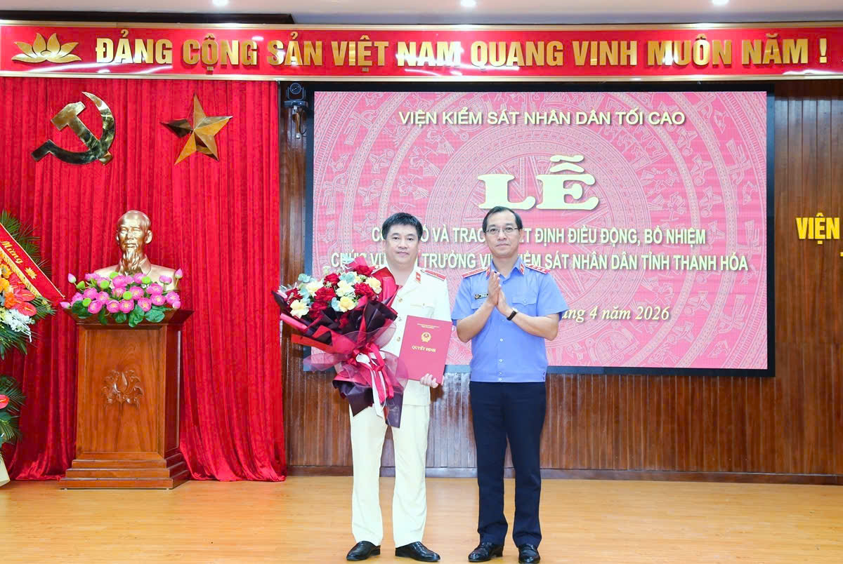 Đồng chí Hồ Đức Anh, Phó Bí thư Thường trực Đảng ủy, Phó Viện trưởng Thường trực VKSND tối cao trao quyết định bổ nhiệm và tặng hoa, chúc mừng đồng chí Nguyễn Tiến Dũng- tân Viện trưởng VKSND tỉnh Thanh Hóa