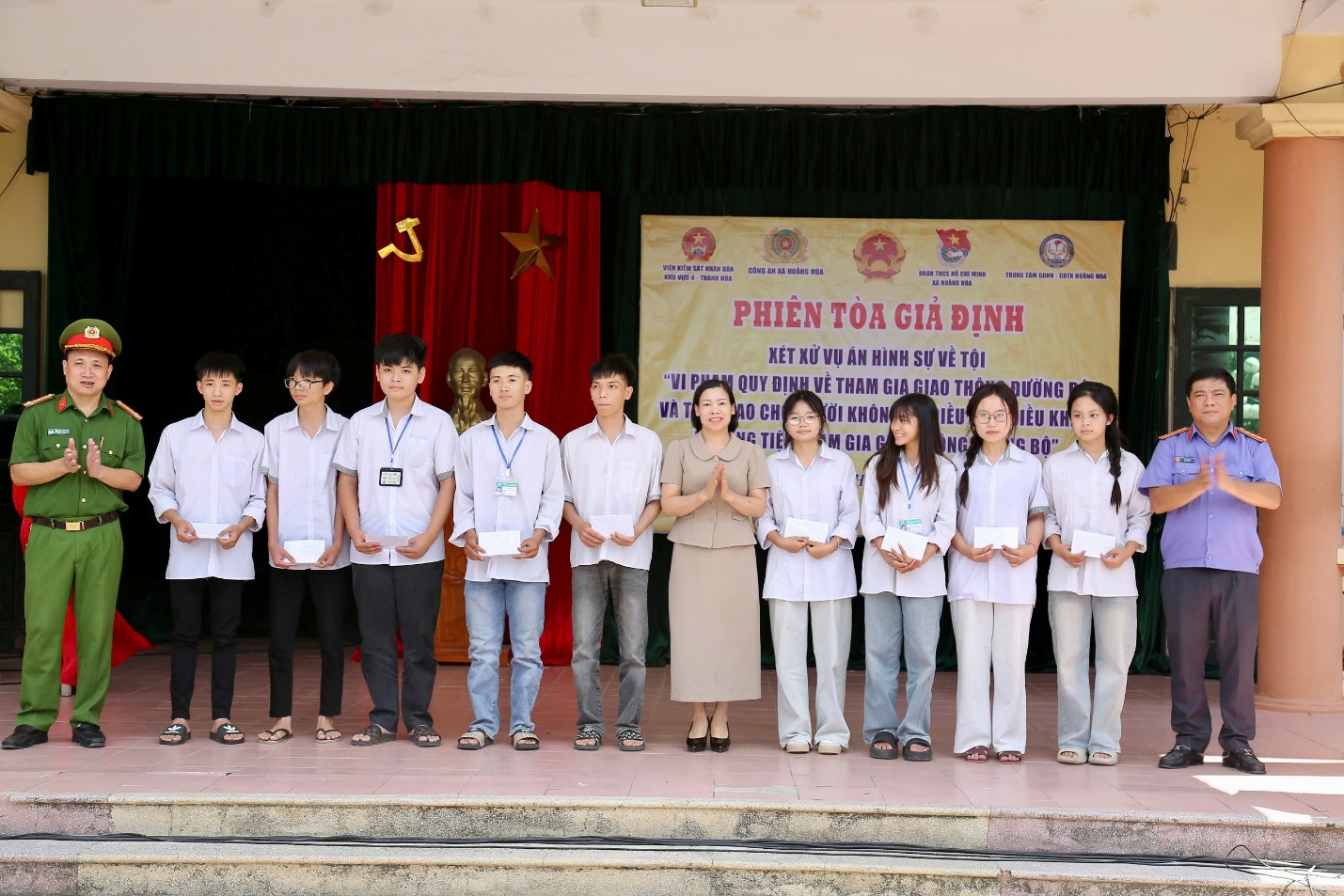Đồng chí Lê Xuân Huy, Viện trưởng VKSND khu vực 4 - Thanh Hoá và đại diện Đảng uỷ, Công an xã Hoằng Hoá trao quà cho các em học sinh có thành tích xuất sắc trong học tập