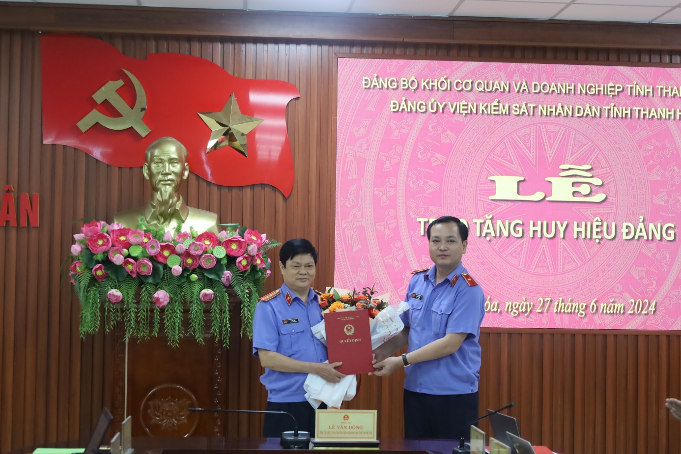 Đồng chí Lê Văn Đông, Bí thư Đảng ủy chúc mừng đồng chí Lê Thế Huệ, đảng viên, Phó Bí thư Chi bộ Phòng 8 VKSND tỉnh nhận huy hiệu 30 năm tuổi đảng